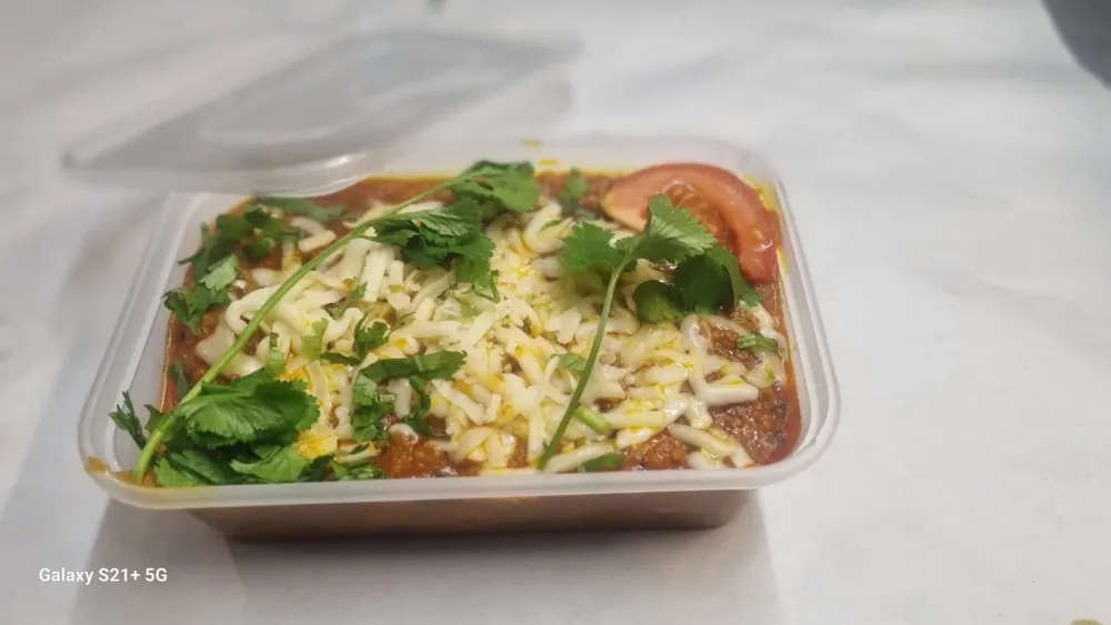 Keema curry topped with melted cheese and coriander