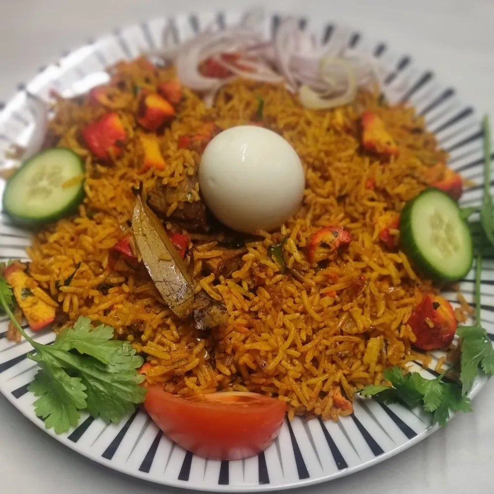 Chicken tikka biryani topped with a boiled egg
