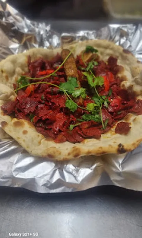 Chicken tikka piled on a fresh naan